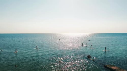 Tourists Floating on SUP Board in Blue Sea