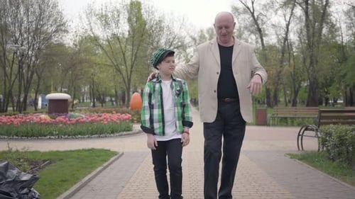 Portrait Cute Grandfather and Adorable Grandson Walking To Camera in the Park