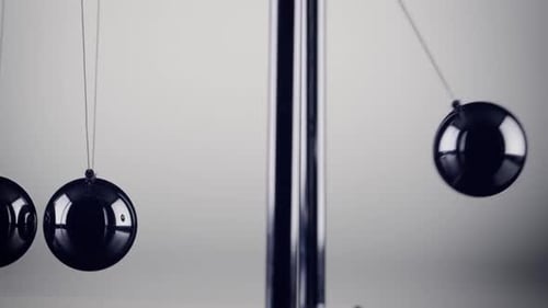 Die Kugeln einer Newtons Cradle kollidieren in Zeitlupe