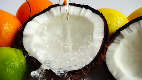 Fresh Water Being Poured into Coconut with Fruit