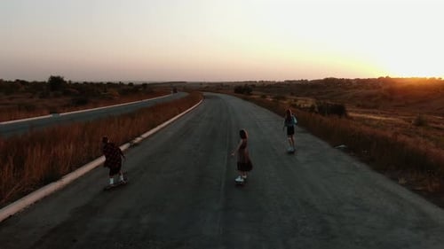 Longboarding, Three Young Ladies Wearing Dresses Having Fun on a Country Road