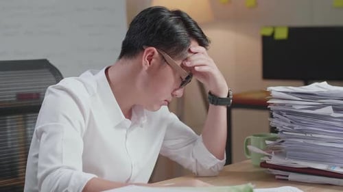 Close Up Of Asian Man Being Tired Working Hard With Documents