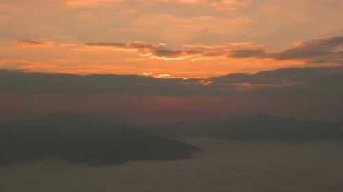 Golden Sunrise Over Mountainous Landscape with Fog