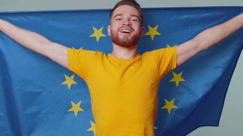 Smiling Man Posing with a Flag Inside