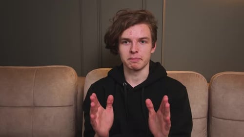 Man Talking to Camera on Couch Indoors