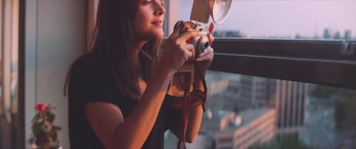 Woman with Vintage Camera Taking City Pictures Indoors