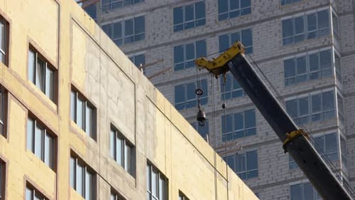 Movimiento de una grúa de construcción de edificios sobre el rascacielos