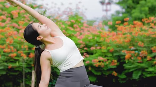 Young asian woman practicing yoga in garden.