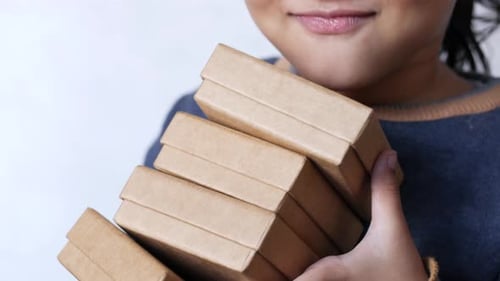 Smiling Child Holding Stack of Birthday Gifts