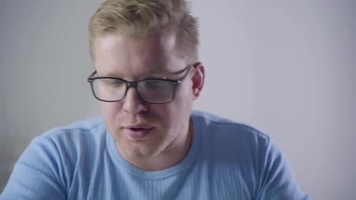 Close-up Portrait of Redhead Caucasian Architect in Eyeglasses Sitting at the Table with Map