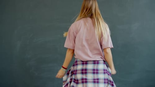 Portrait of Good-looking Young Lady Dancing in Modern Studio on Grey Background