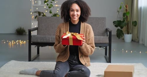 Young Woman Presents Beautifully Wrapped Gift