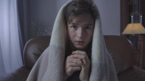 Portrait of Scared Teenager Watching Horror Movie at Night. Close-up of Frightened Brunette