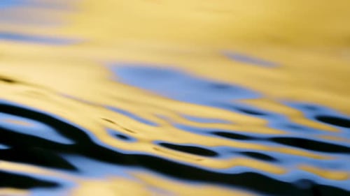 Water surface yellow and blue texture with clean ripples and wave refraction background. Slow motion