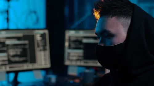 Hacker asiatique dans la chambre noire avec des ordinateurs la nuit 50