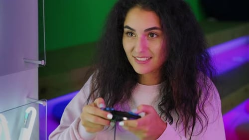 Young Woman Plays Video Game in Arcade