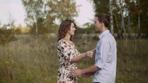 Young Couple Walking on a Meadow