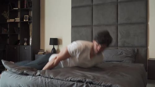 Tired Person After a Hard Day at Work Falls on the Bed with His Eyes Closed and Sleeps in Slow