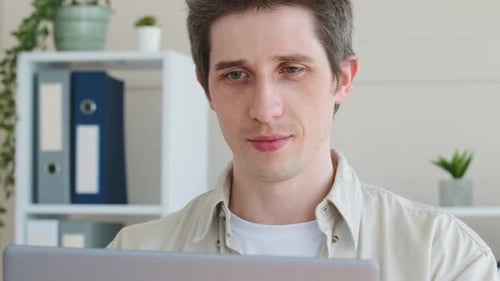 Man Looking at Laptop Screen Indoors