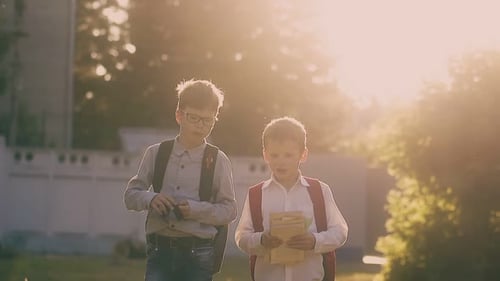 Niños en camisas y siluetas caminan con libros después del examen
