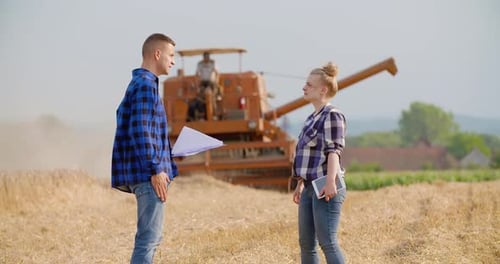 Female Farmer Discussing With Businessman On Farm