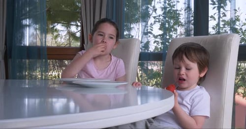 Children Enjoying Fresh Strawberries at Table Indoors