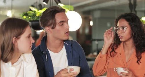 Crop View of Young Colleagues Drinking Coffee and Talking While Having Break. Millennial Successful