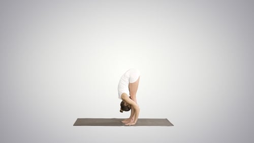Beau modèle faisant un exercice de yoga debout à Uttanasana