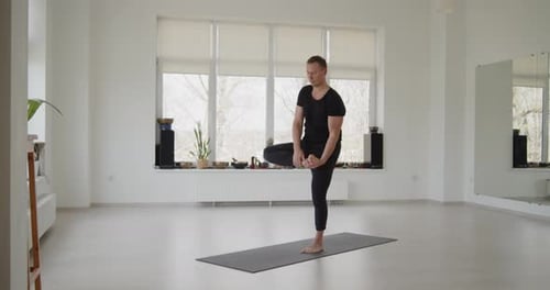 Man Doing One-Legged Yoga Pose on Mat