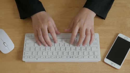 Hands Typing on White Keyboard at Desk