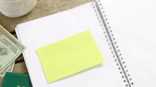 Notebook, Passport, and Map on Wooden Table