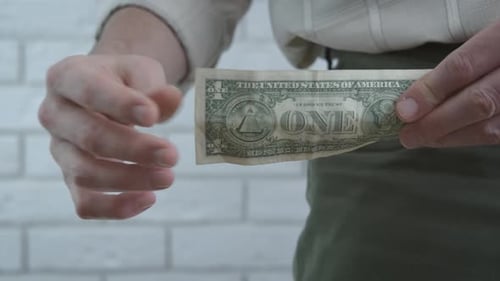 Man Pulls Dollar Bill From Pocket, Thumbs Up