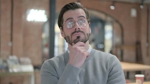Man Contemplating with Hand on Chin in Workplace
