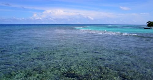 Weites Vogelaugenfoto eines sonnenweißen Sandparadiesstrandes und eines aquablauen Ozeanhintergrunds