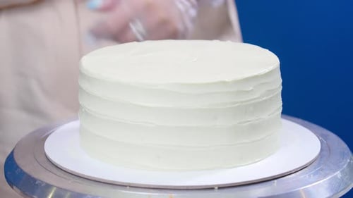 Chef Smoothing White Icing on Cake with Spatula