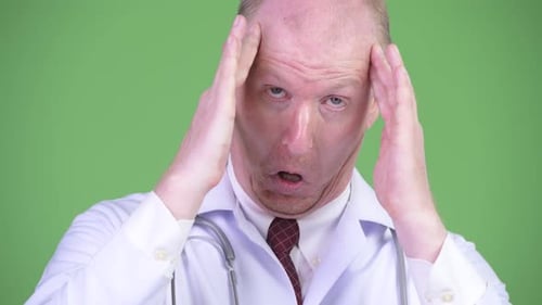 Stressed Doctor Holding Head in Pain