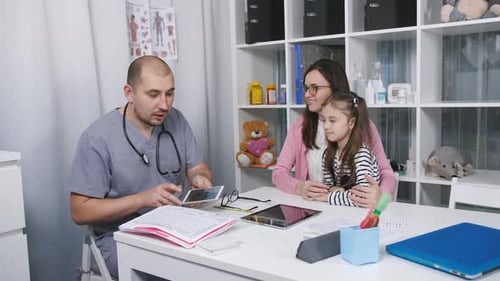 Doctor Talking to Mother and Child in Office