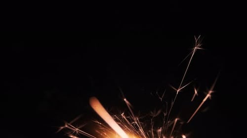 Bright Sparkler Emitting Light and Sparks on Dark