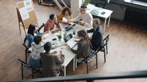 Business Teammates Talking and Exchanging Documents Working at Project in Office