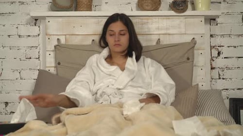 Une fille caucasienne a le nez qui coule en utilisant des serviettes dans la chambre.