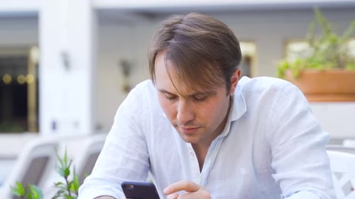 Man using phone in cafe.