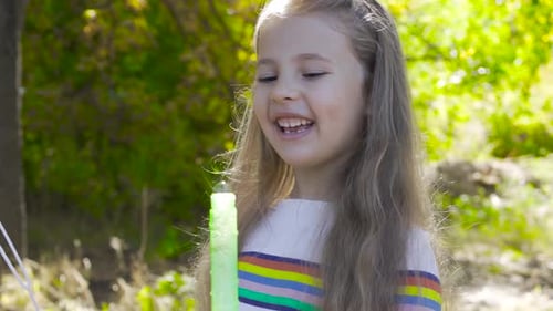 Girl Blowing Bubbles Outdoors in a Park