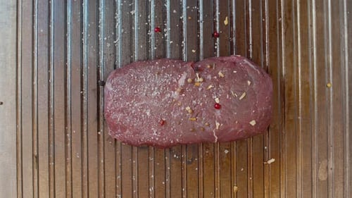 Raw Steak Seasoned on a Metal Grill