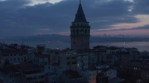 Establishing Shot of Galata Tower at Dark Blue Hour with Bosphorus in Background and Red Purple Sky