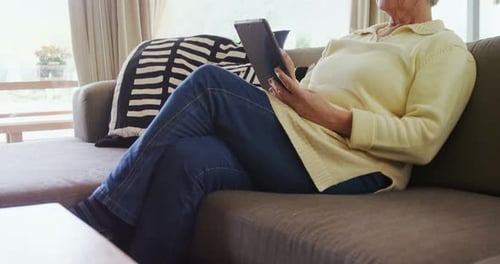 Senior Woman Relaxing at Home Using Tablet