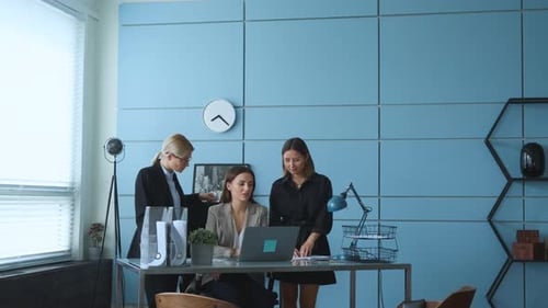Three Young girls are talking about business in their office and checking documents