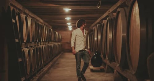 Man Walking Through Historic Wine Cellar