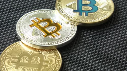 Bitcoin Coins Resting On Black Woven Surface