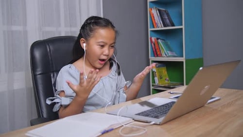 Girl Learning Online with Laptop and Earbuds