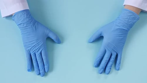 Gloved Hands Form Heart on Blue Background